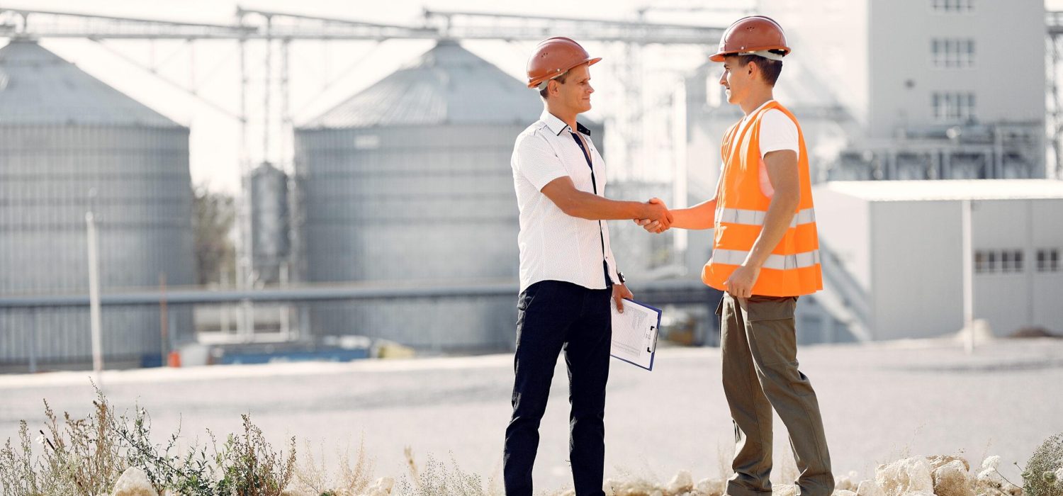 Engineers near the factory. Mtn in a helmet. Inspector looks at the building.