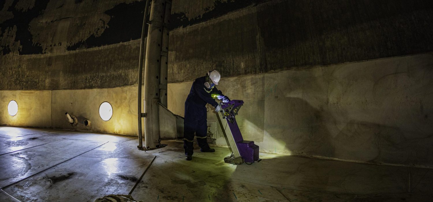 Male worker inspection floor scan tank external floating of rust wall lose thickness bottom plate in manhole tank to work inside confined