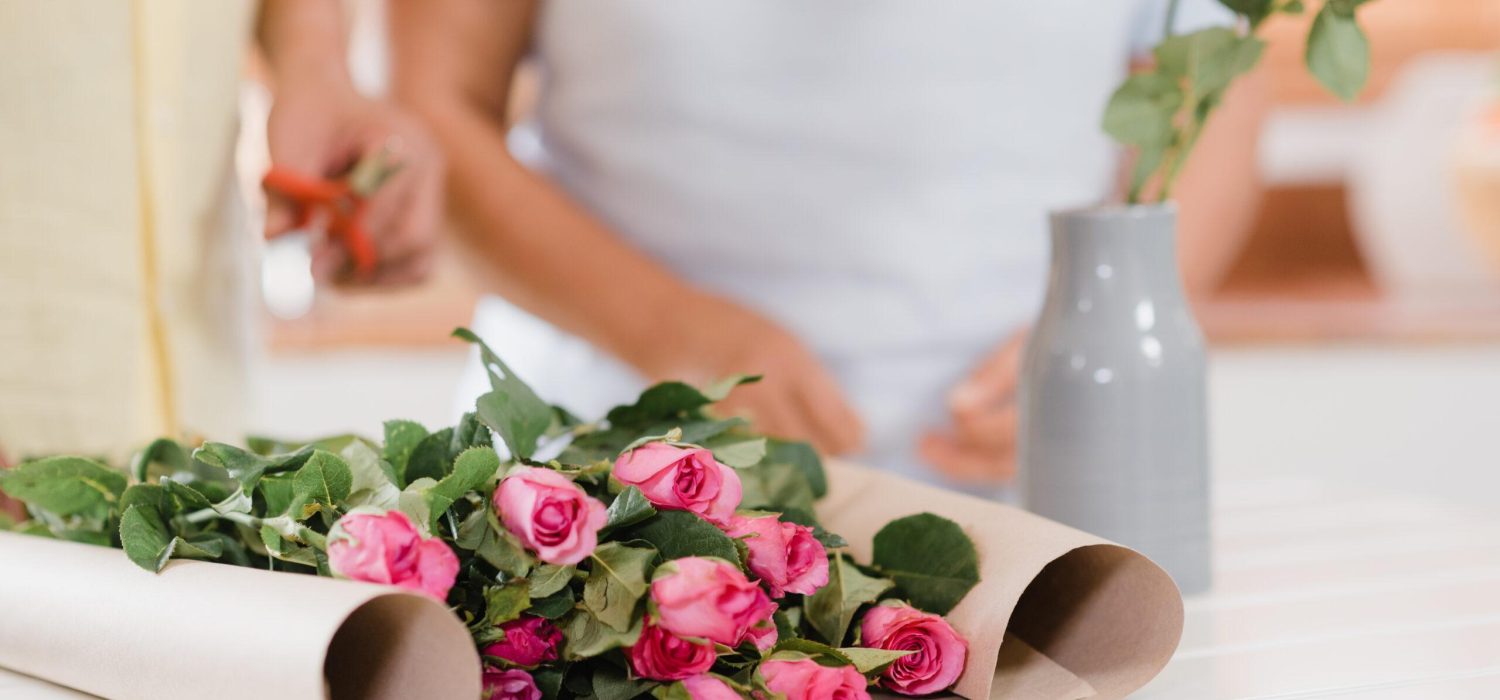 Asian elderly couple making bouquet flowers on a wooden table in kitchen at home. Chinese sweet senior couple using time relax together at home. Lifestyle senior couple at home concept.