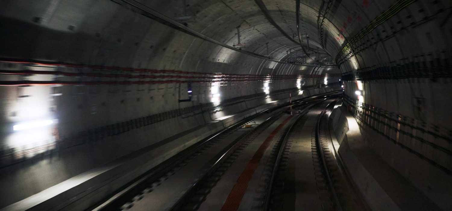 Dynamic photo of an underground or funicular tunnel with two tracks and bright lights